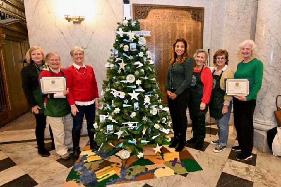 Members of the Talbot County Garden Club and the Oxford Garden Club with Maryland's First Lady Dawn Moore around the Easton Airport 80th Themed Tree at the State Capitol Rotunda.