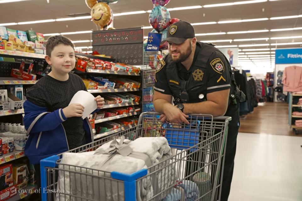 Deputy First Class D. Scrivener of Talbot County Sherriff's Office does some holiday shopping alongside his partner at Walmart in Easton for the Talbot Optimist's 'Shop with a Cop' event.
